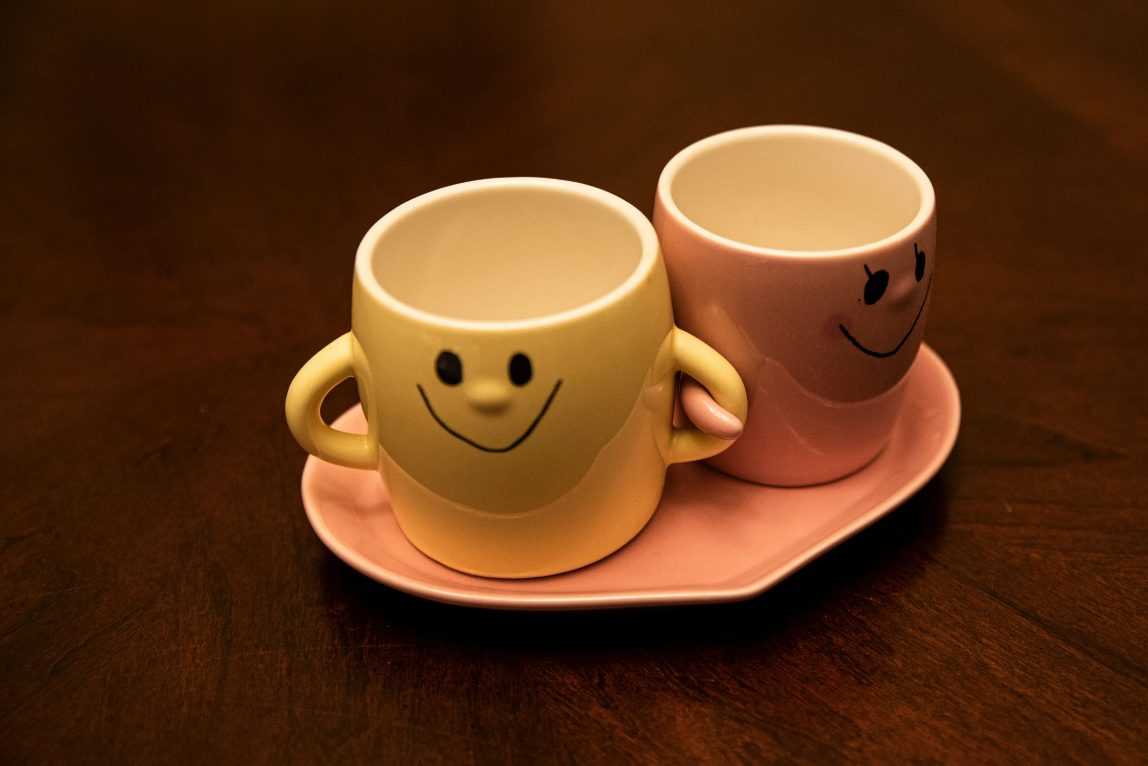 a couple of cups with faces on a plate