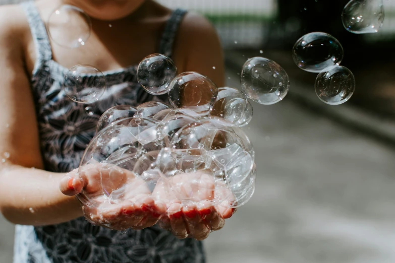 a person is holding bubbles in her hand