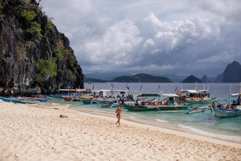 there are many boats sitting on the beach by the water