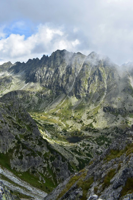 some very beautiful mountains with clouds and grass