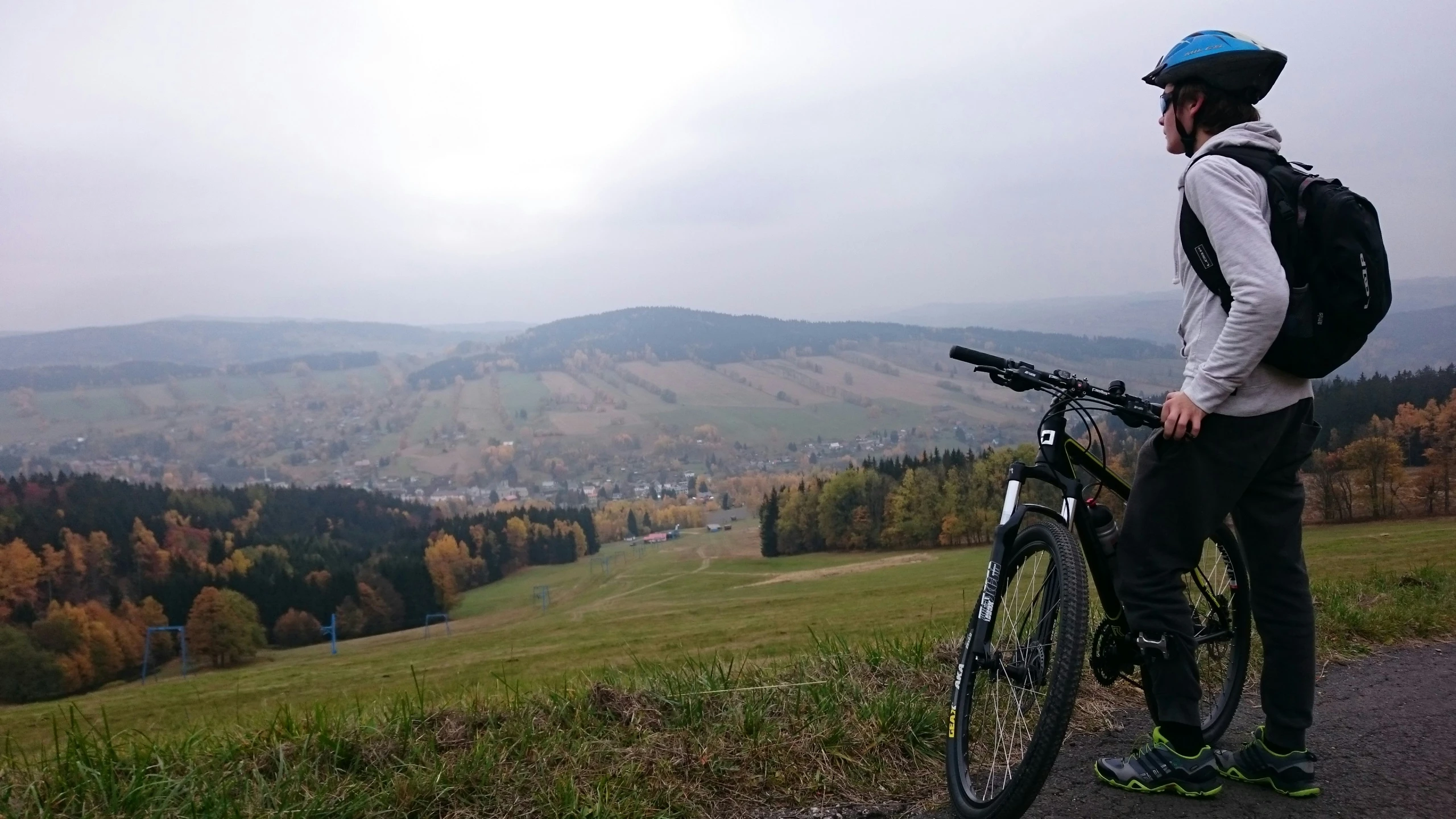 the back of a mountain biker with a bicycle in hand