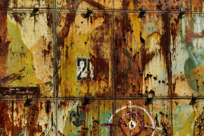 a rusted wall with a large face painted on it
