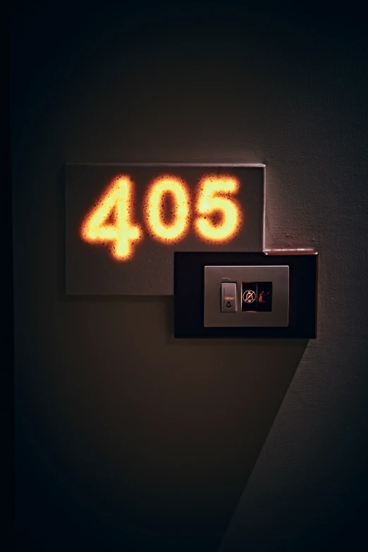 a wall mounted clock with yellow light on it