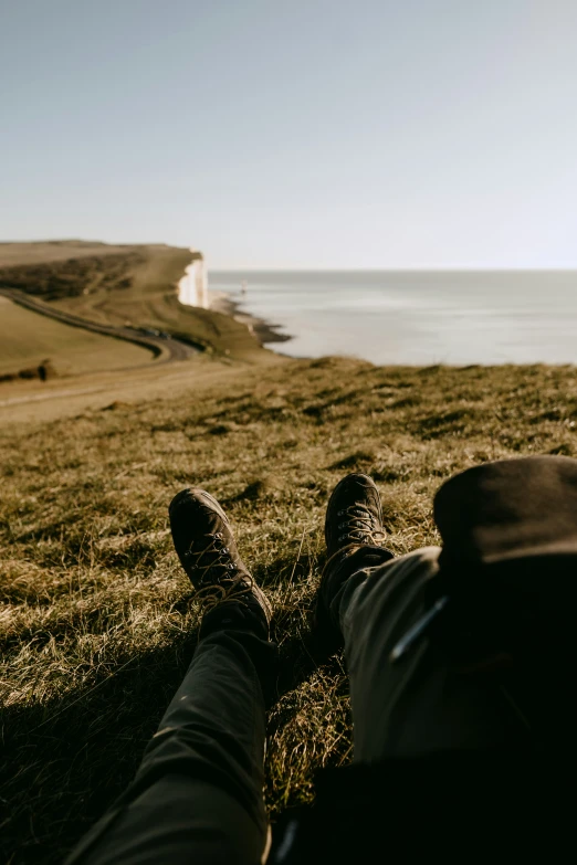 man relaxing on the green grass by the sea