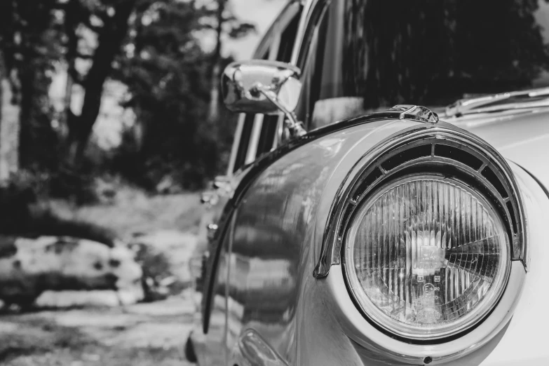 the front end of an old car with a small light