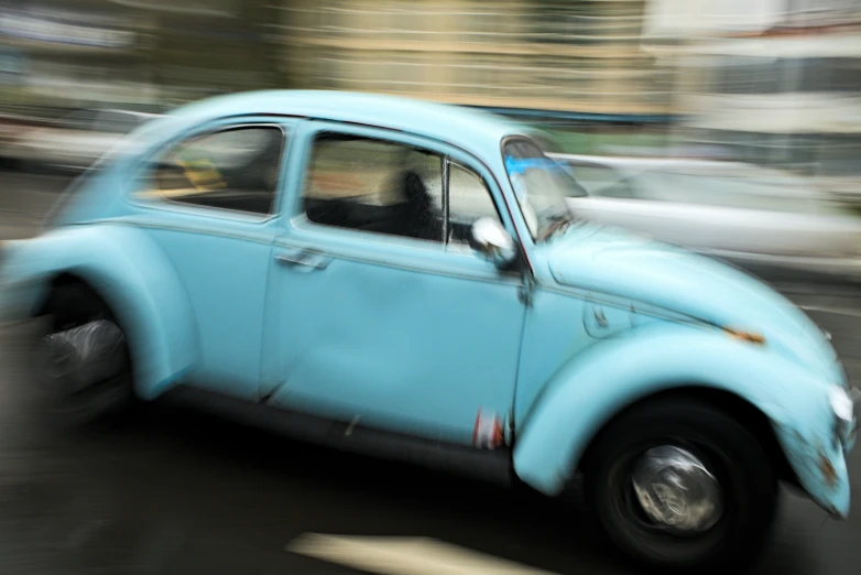 a blue car is driving down the road