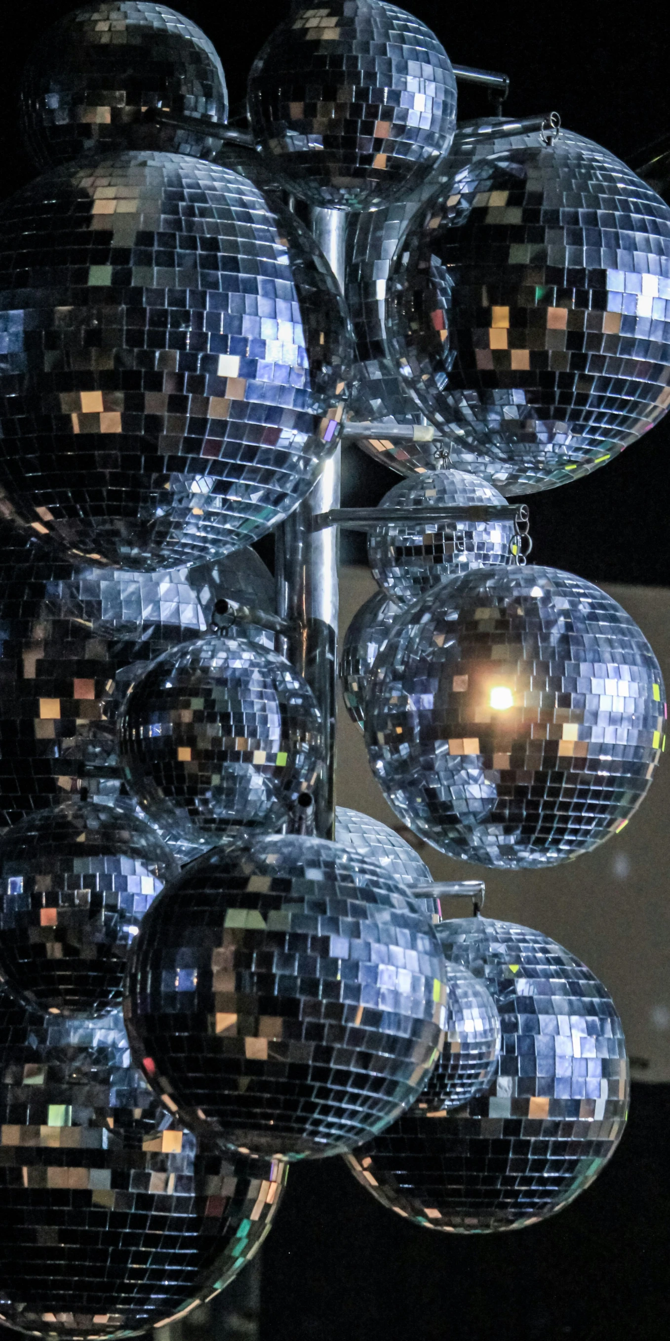 a pole with several large shiny disco ball decorations