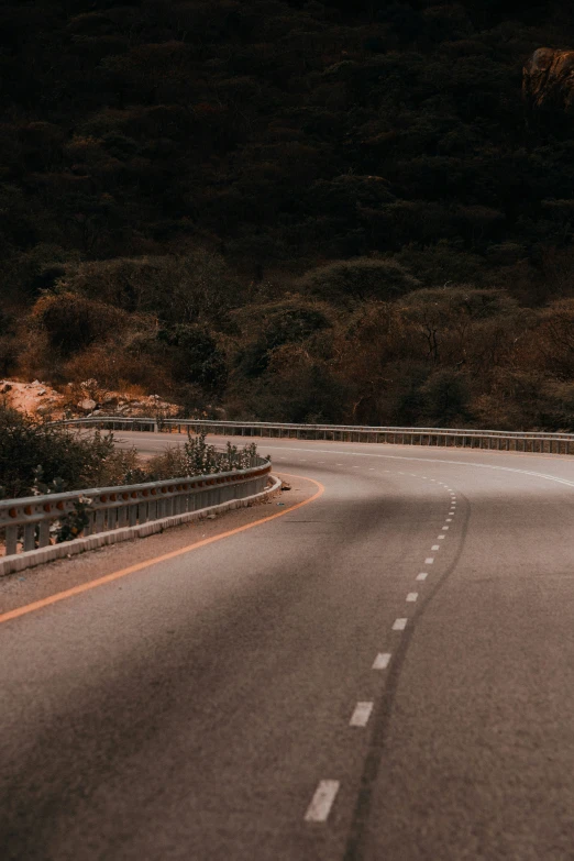 a long road going through the mountains into the dark