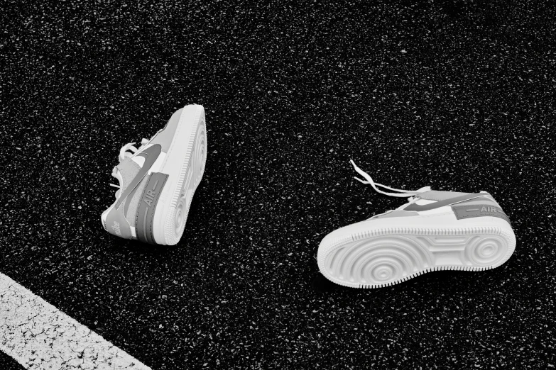 a pair of black and white sneakers against a black and white background