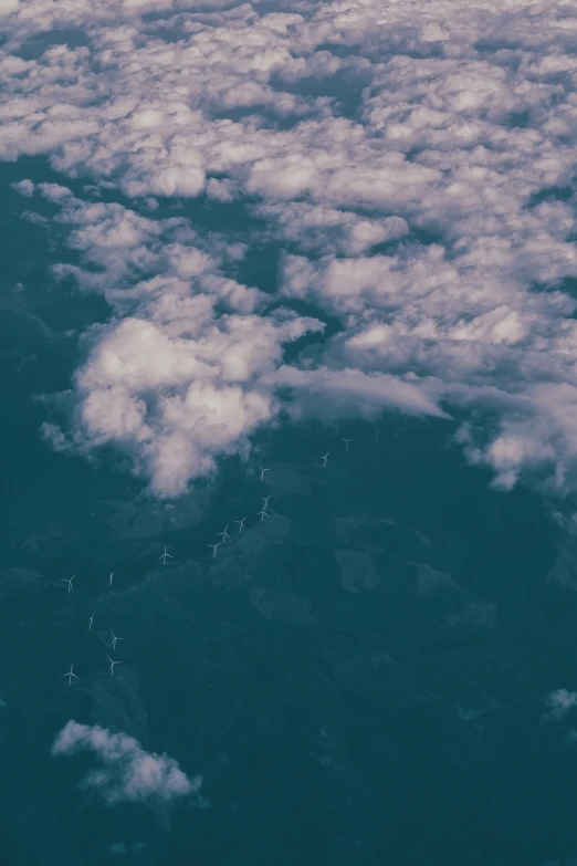 the view out an airplane window shows several clouds