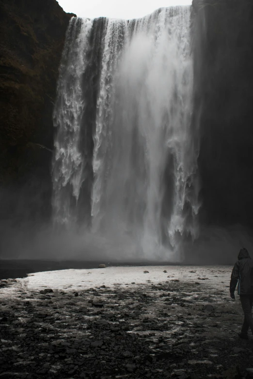 a man in a wetsuit under a waterfall