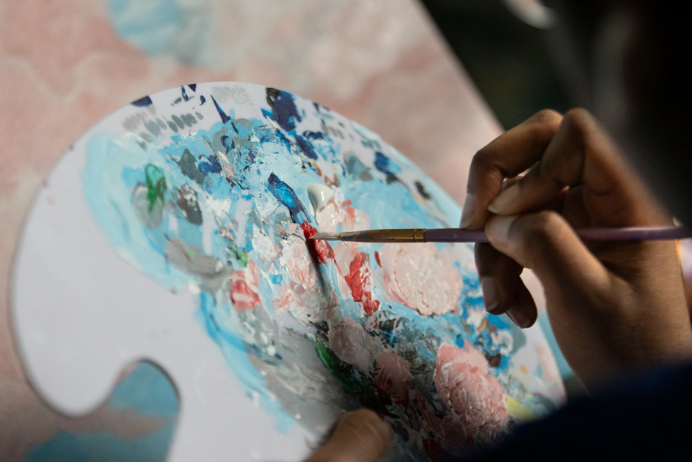 a woman is painting on a palette in her hands