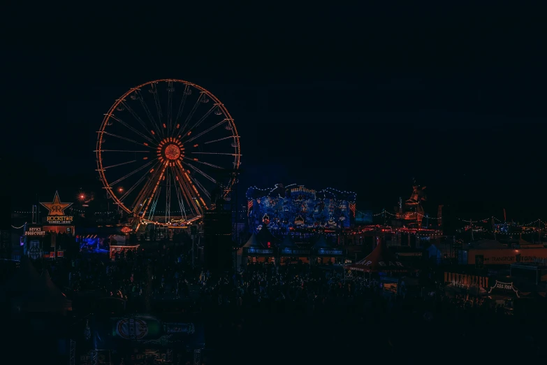 a large ferris wheel with city lights in the background