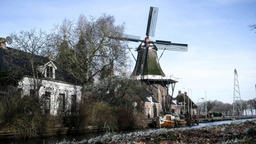 a white building with a black windmill next to it