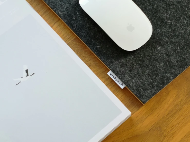 the apple computer mouse is next to an empty apple mouse pad