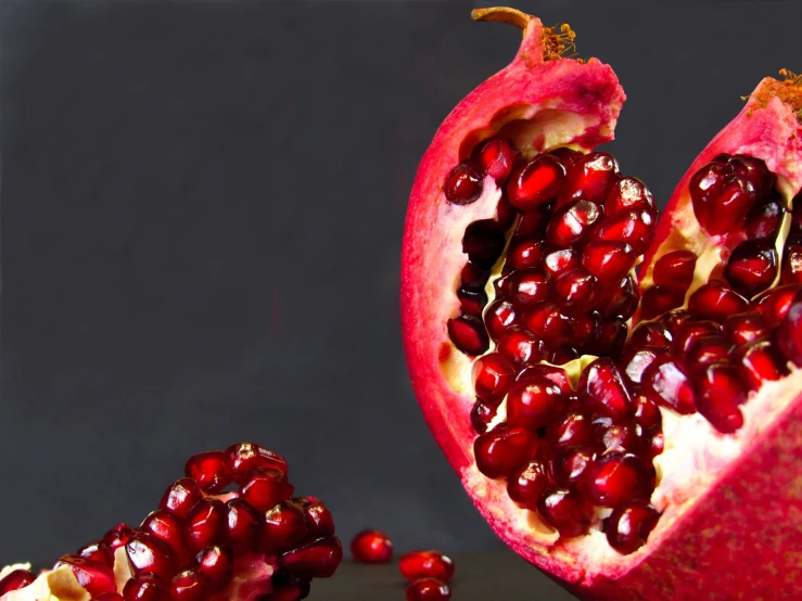 a pomegranate cut in half on a black background
