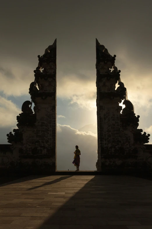 a woman walks through a set of ornate archways