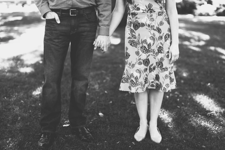 a couple of people holding hands in a field