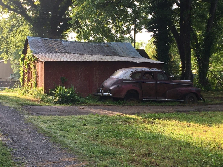 an old car is parked outside a small building