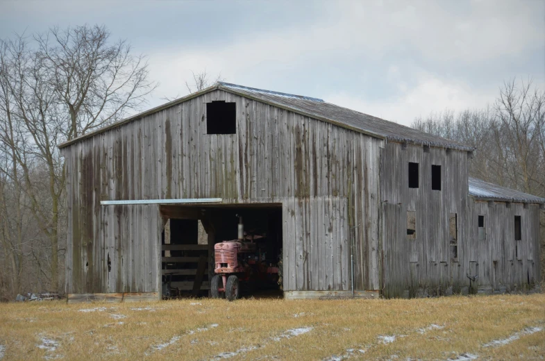 a horse and a wagon are standing in the doorway of an old barn