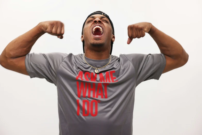 a man is yelling while wearing an army shirt