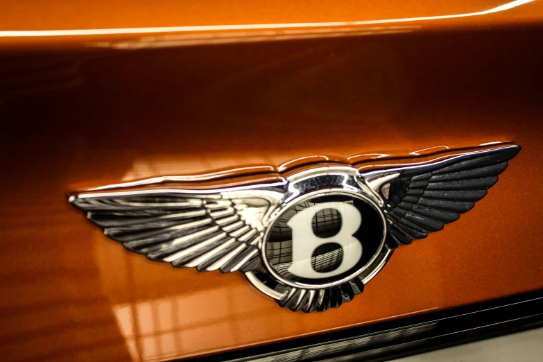 the bentley badge is on a vehicle's orange paint
