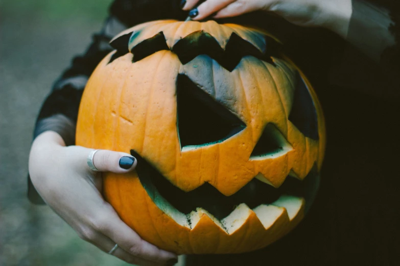 a person is holding a jack o lantern in their hands