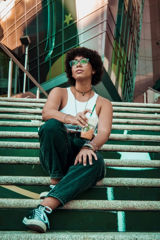 a woman in sunglasses poses on the steps of stairs