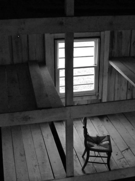 looking down from a loft through a small window in an unfinished house