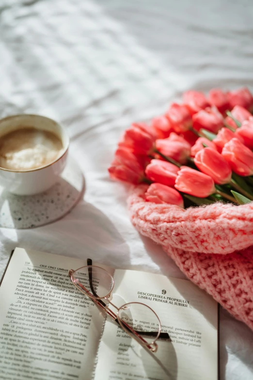 red tulips with yarn covering a book and glasses