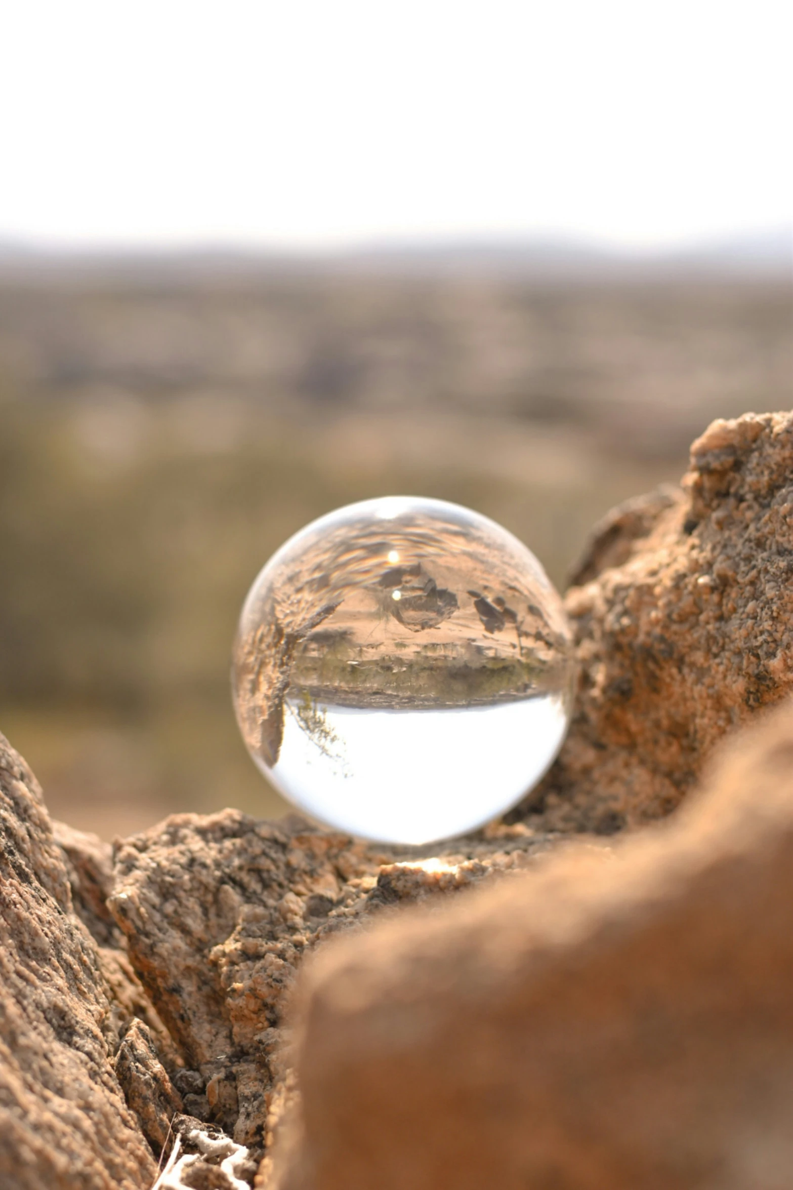 a reflection of the desert in a glass ball