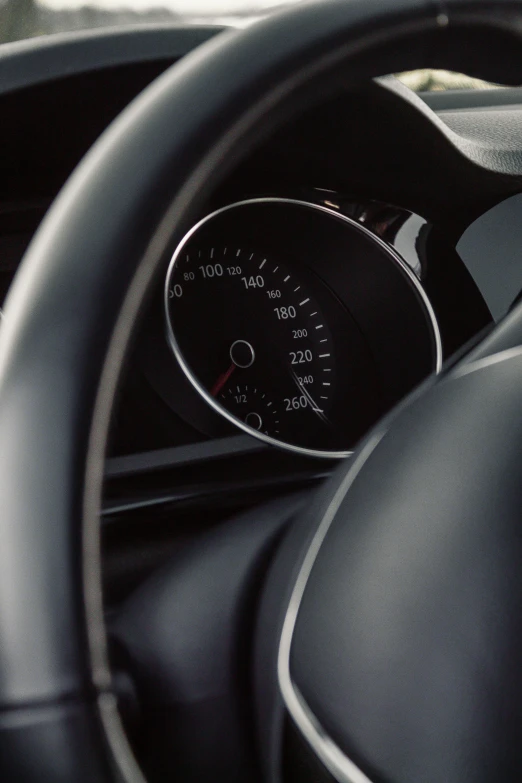 the dashboard of an automobile, with a speed gauge and dash light