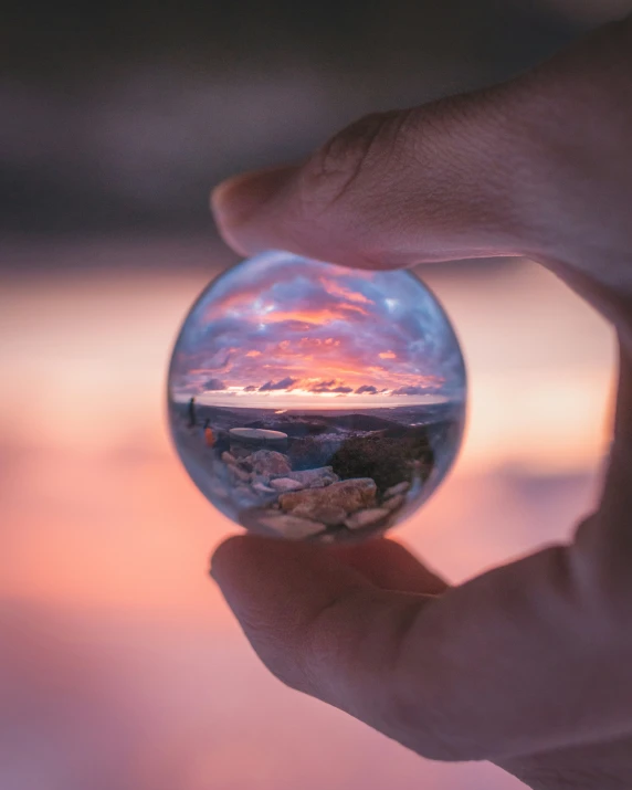 a close up of a person's hand holding a glass ball