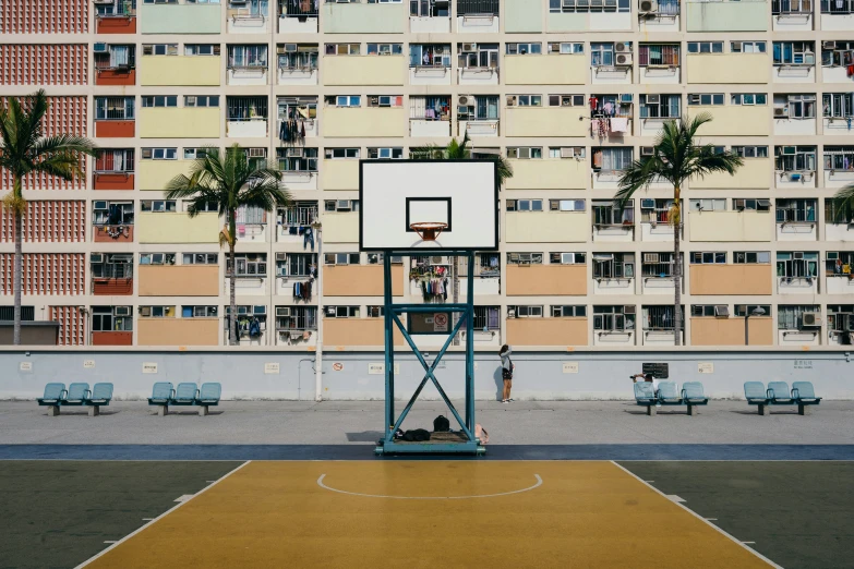 a big building is in the back ground with a basketball court