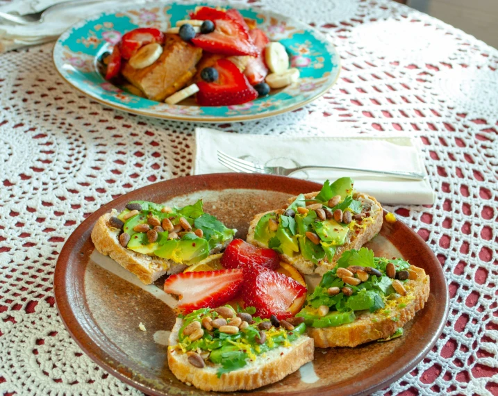 a brown plate topped with sandwiches and sliced strawberries