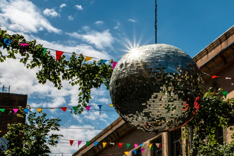 an outdoor disco ball on the sidewalk with bunting