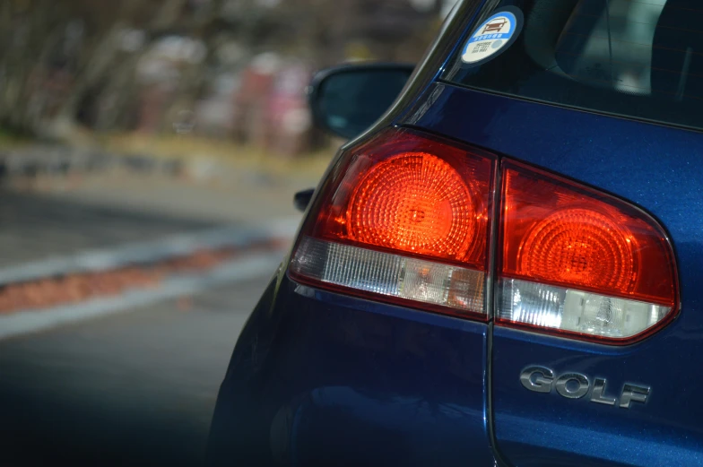 a blue car is on the street with it's ke lights