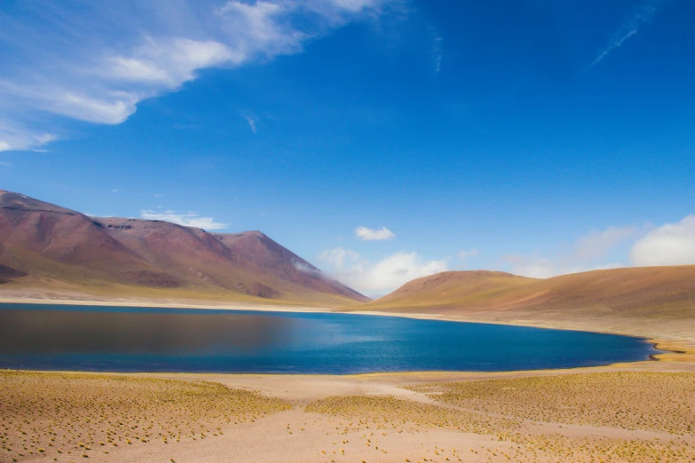 the small body of water in the desert has mountains around it