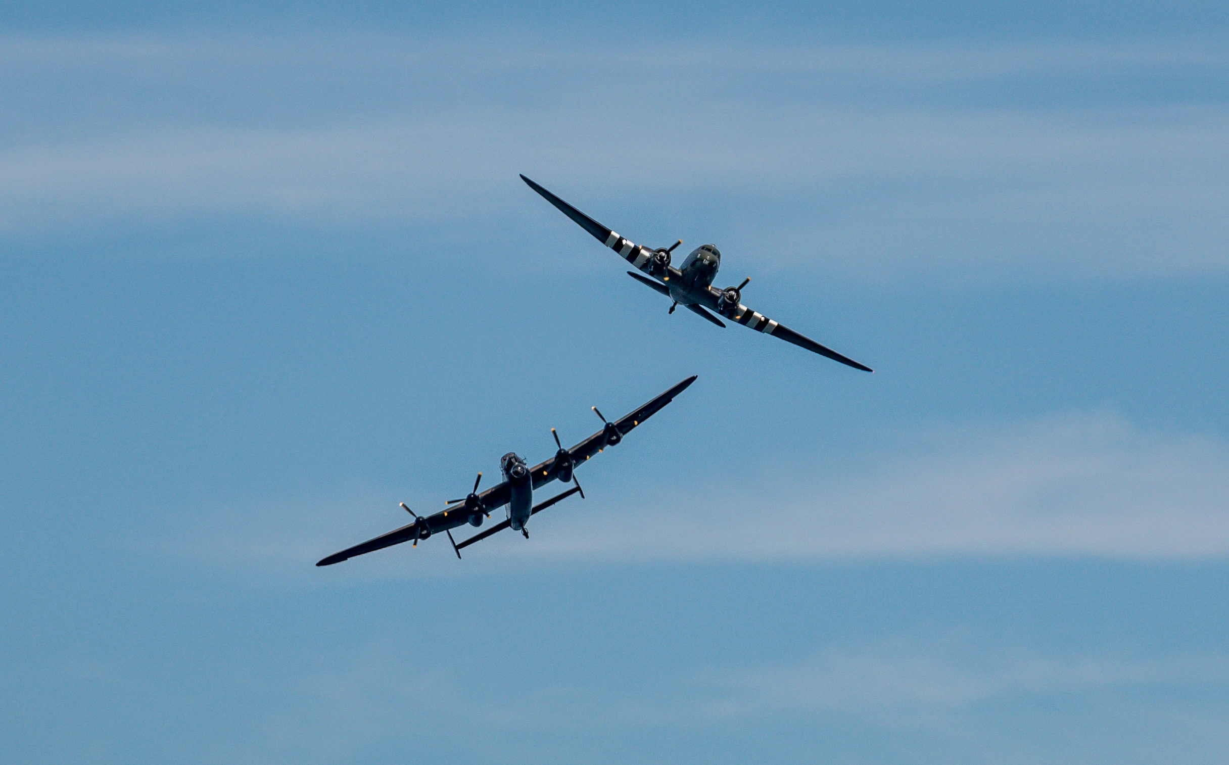 two old fashioned airplanes fly in the clear blue sky