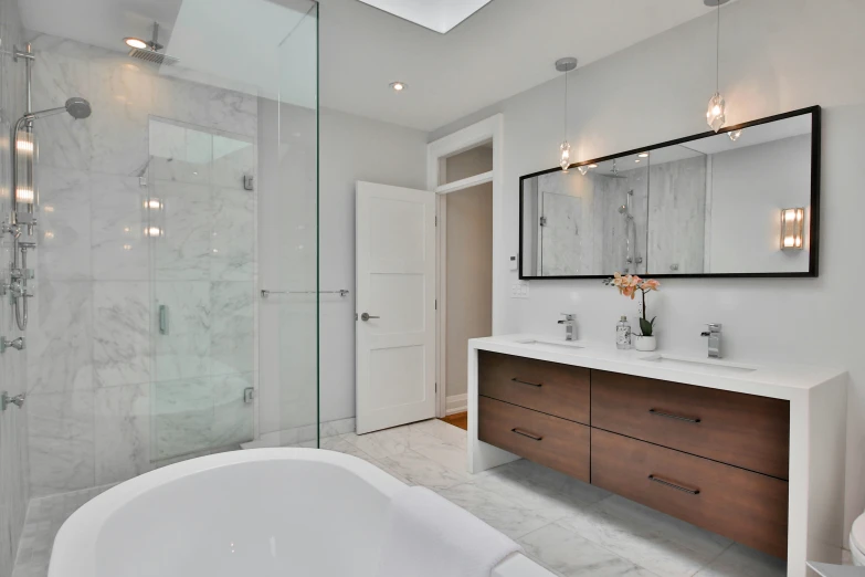 a modern bathroom has double sinks, mirrors, and a large tub