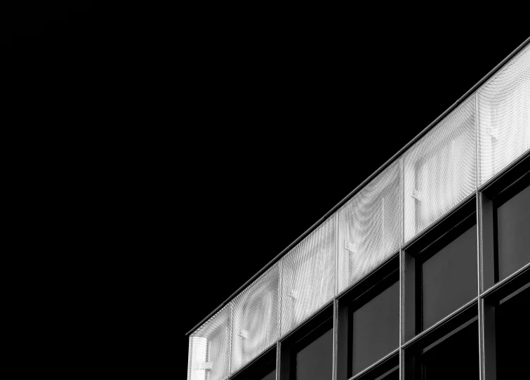 a plane flies over a large building with some windows