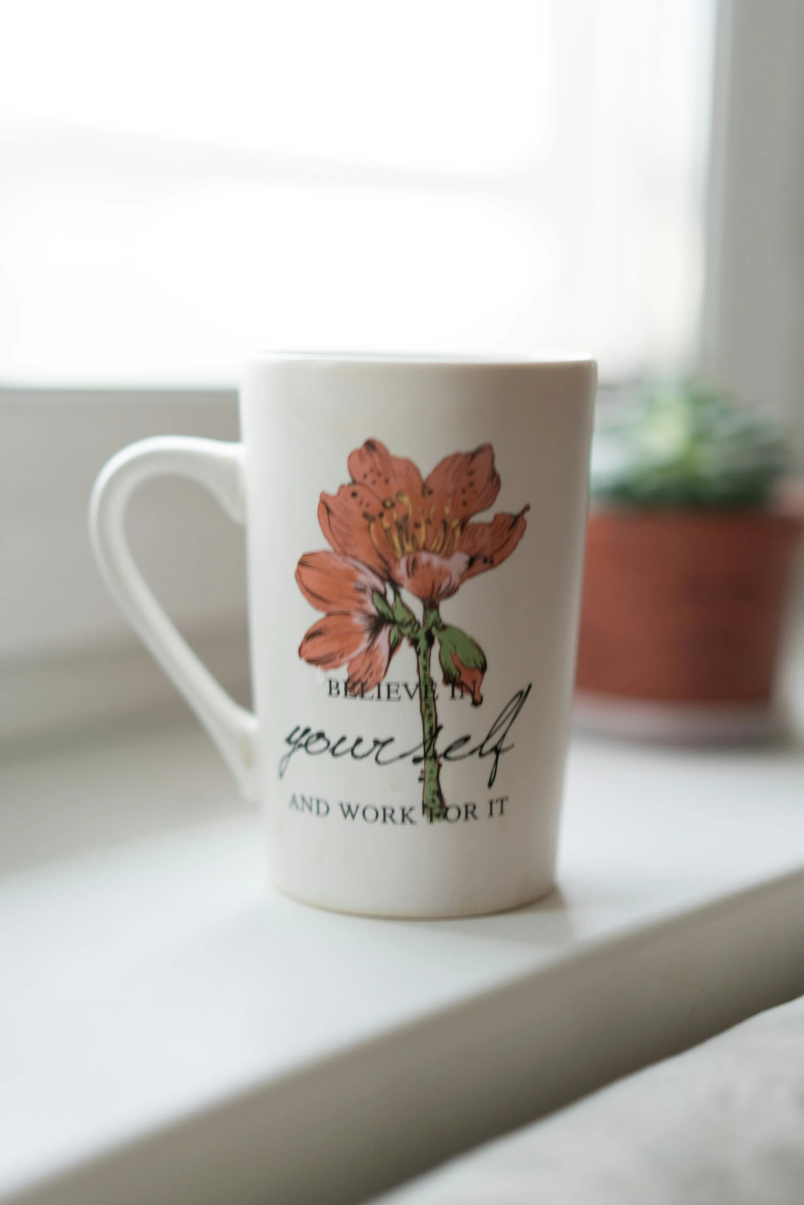 there is a coffee cup on a window sill