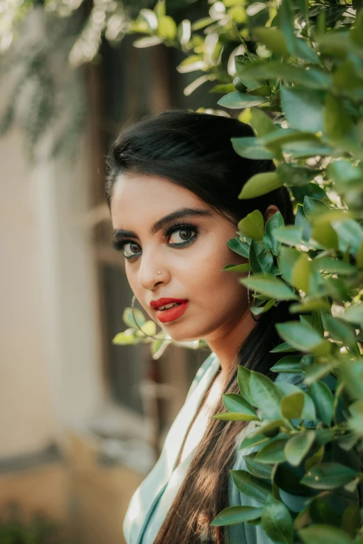 a girl with a ponytail stares into the distance behind her leaves