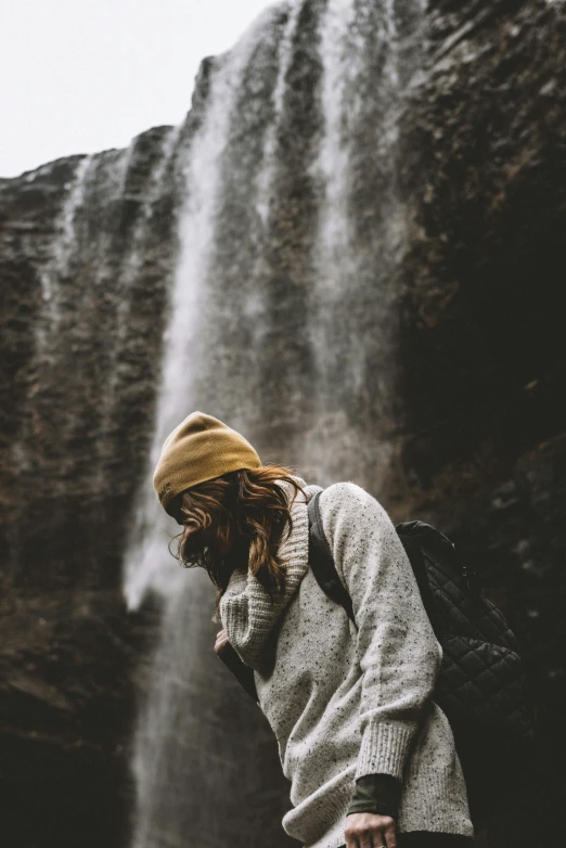 a girl standing next to a big waterfall