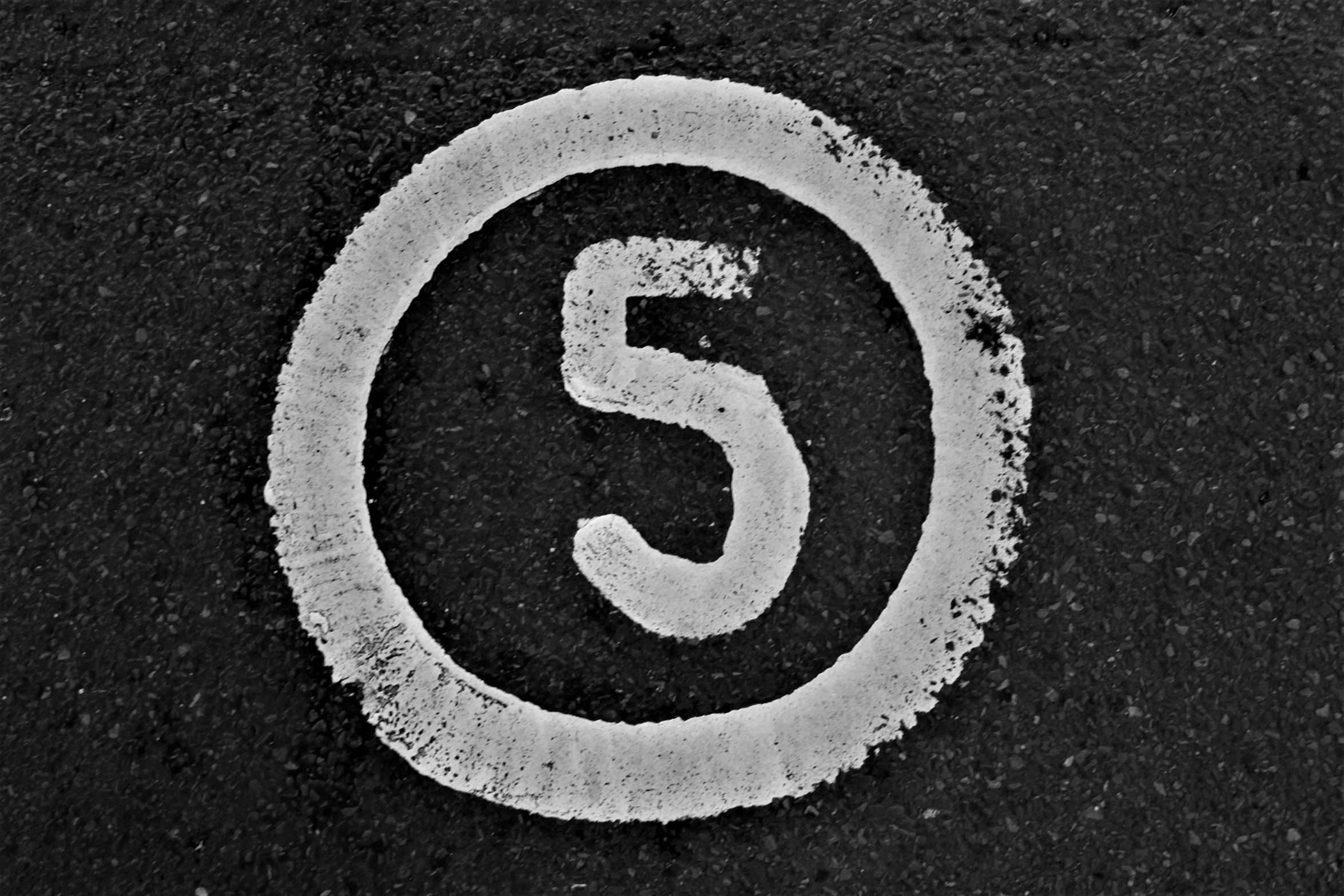 the number 5 written in white on the asphalt