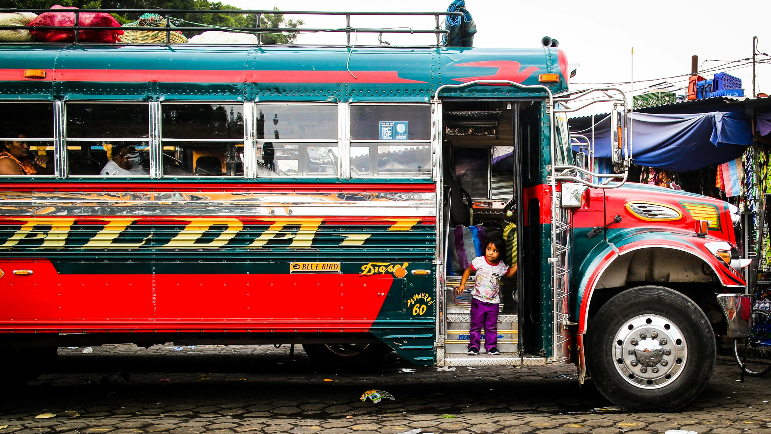 colorful bus with passengers entering and exiting in traffic