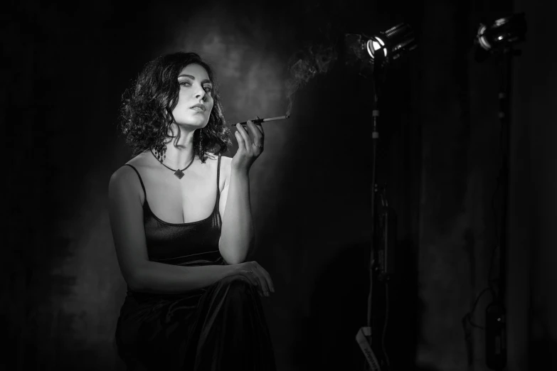 a woman is sitting down while smoking a cigarette