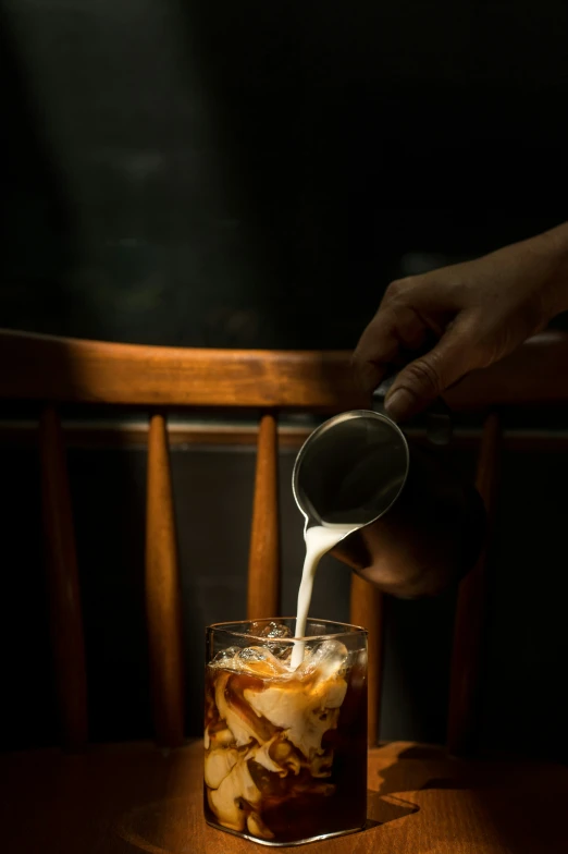 an individual is drizzing the liquid onto their food