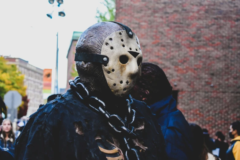 man in costume with chains wearing an odd mask