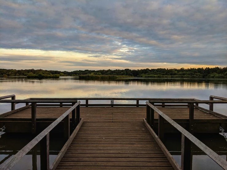 an empty pier in the middle of a lake